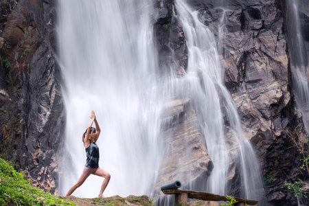 Asian traveller woman pose yoga in lotus pose with waterfall background at Chiangmai, Thailandの写真素材