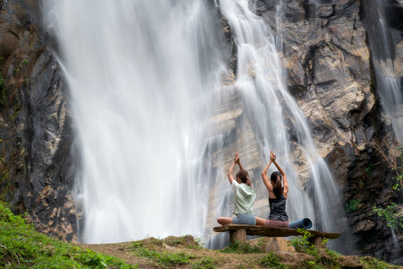 Asian traveller woman pose yoga in lotus pose with waterfall background at Chiangmai, Thailandの写真素材