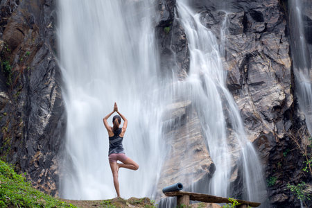 Asian traveller woman pose yoga in lotus pose with waterfall background at Chiangmai, Thailandの写真素材