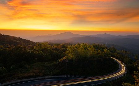 Landscape view point at top of doi Inthanon national park on winter season with light from car and roat with nature, mist and sun light background in Chiang mai, Thailandの写真素材
