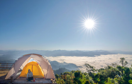 Asian business woman working with her computer between her camping tent trip at Chiang mai, Thailandの写真素材