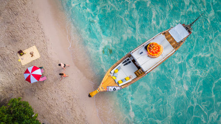 Top view of travel boat, traveller couple, beach and blue sea in summer time at Phuket, Thailandの写真素材