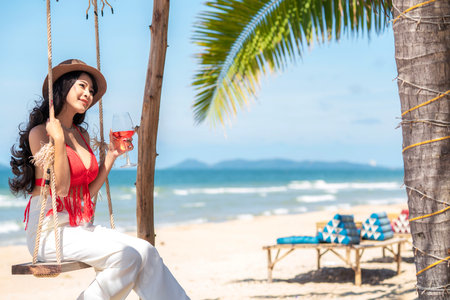 Asian tourist woman in orange bikini on the beach at Phi Phi island in Phuket, Thailandの写真素材
