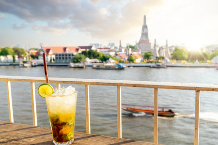 Juice beverages in the rooftop bar with Wat arun and Arun pagoda and sunset background in Bangkok city, Thailandの写真素材