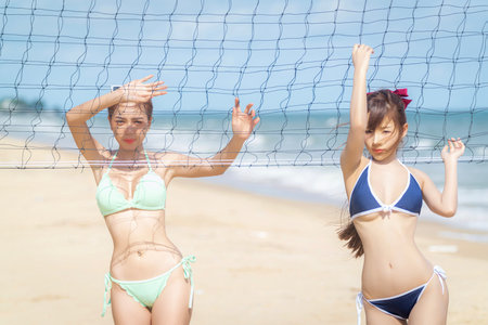 Asian woman volleyball player on the beach with ball on hand with beach and summer background between travel in Thailand islandの写真素材