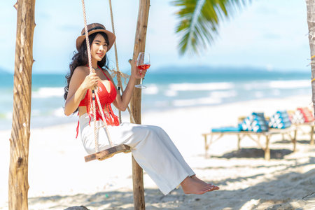 Asian tourist woman in orange bikini on the beach at Phi Phi island in Phuket, Thailandの写真素材