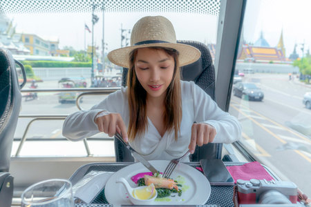 Asian traveller woman take a lunch on the restaurant bus between city tour by bus with wat phra kaew and Thailand grand palace bangkokの写真素材