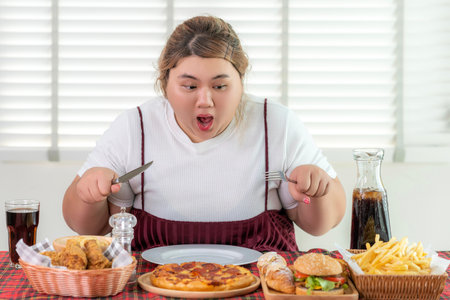 Asian over size fat woman enjoy eating on the restaurant, un healthy foods and junk food concept photoの写真素材