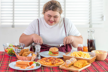 Asian over size fat woman enjoy over eating on the restaurant, un healthy foods and junk food concept photoの写真素材