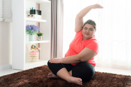 Asian fat woman workout with yoga post action for exercise and diet in fitness center clubの写真素材