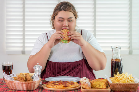 Asian over size fat woman enjoy over eating on the restaurant, un healthy foods and junk food concept photoの写真素材