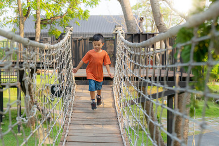 Asian boy play a wooded toy on the grass in green garden and city park in bangkok cityの写真素材