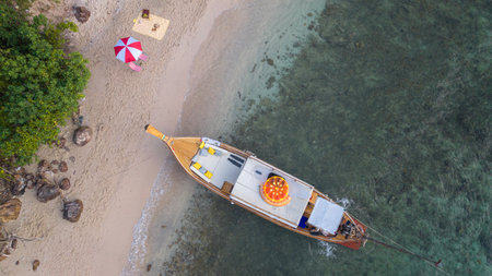 Asian traveller couple sitting and see sunset togather on the beach with longtail boat background at Phi phi island maya beach near Phuket, Thailandの写真素材