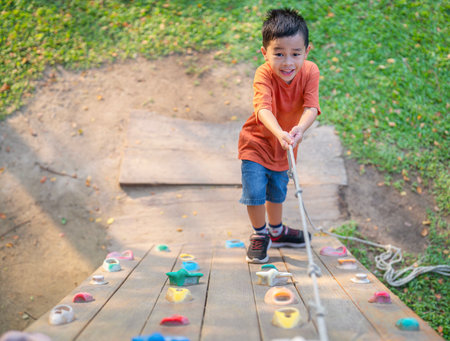 Asian boy play a wooded toy on the grass in green garden and city park in bangkok cityの写真素材