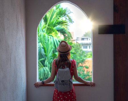 Asian woman in red dress relax and see view at the windows in resort in Chiang mai, Thailandの写真素材