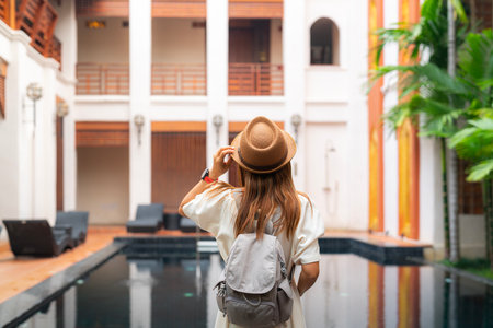 Asian woman traveller relax in resort and swimming pool in Hotel in Chiangmai, Thailandの写真素材