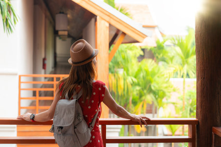 Asian woman in red dress relax and see view at the windows in resort in Chiang mai, Thailandの写真素材