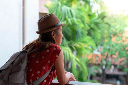 Asian woman in red dress relax and see view at the windows in resort in Chiang mai, Thailandの写真素材
