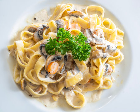 mushroom cream sauce spaghetti on white dish put on the wooded table in italian restaurantの写真素材
