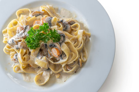 mushroom cream sauce spaghetti on white dish put on islated white background, die cut object for made a food menu in restaurantの写真素材