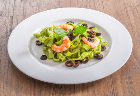italian food on wooded table, Petto sauce with shrimp, spaghetti, herb and basilの写真素材