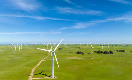 wind power plant and windmill turbine farm in san francisco, california, USA with green grass and...