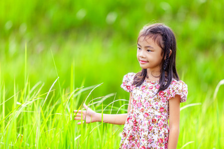 Asian girl play and enjoy in green meadow with bubble, kid and natureの写真素材