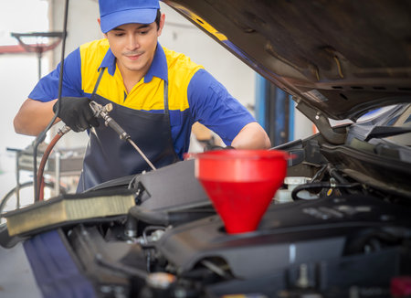 repairman and technician in car garage service in blue uniform standup and smile with tooling on hand for car check andの写真素材