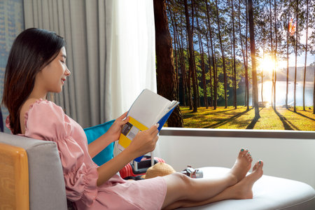 Asian woman traveller open curtain of hotel room for see view after arrival to Doi and  mountain resort in Chiang mai, Thailandの写真素材