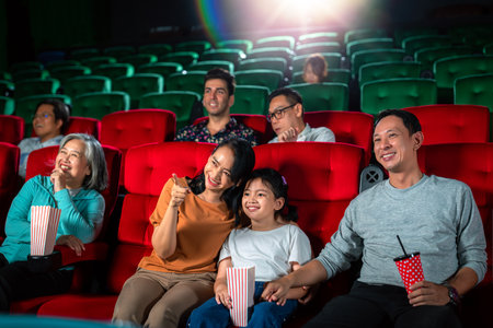 Happy group of asian family and grandmother relax and go to Cimema in movie theater and buy ticket and popcorn in sales counter serviceの写真素材