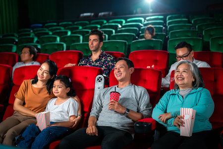 Happy group of asian family and grandmother relax and go to Cimema in movie theater and buy ticket and popcorn in sales counter serviceの写真素材