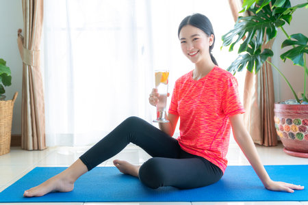 Asian woman exercise in her living room with yoga mat in homeの写真素材