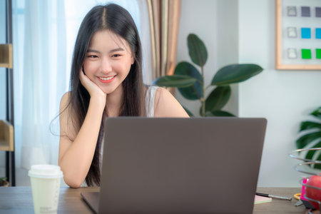 Asian business woman working in home office on the table with computer notebook and coffee cupの写真素材