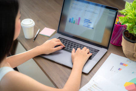Asian business woman working in home office on the table with computer notebook and coffee cupの写真素材