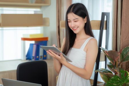 Asian business woman working in home office on the table with computer notebook and coffee cupの写真素材