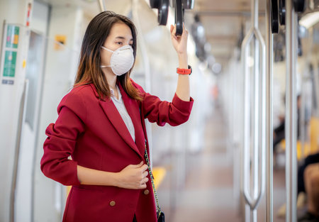 female passenger Standing on the BTS while traveling in Bangkok During the epidemic and air pollutionの写真素材