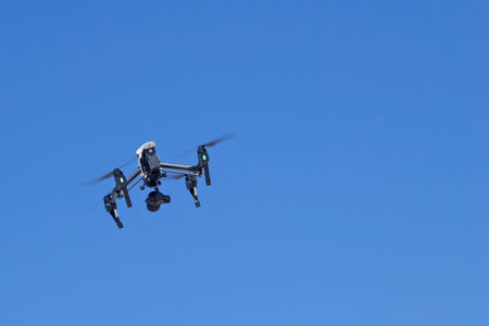 Drone with digital camera on cloudless, blue sky