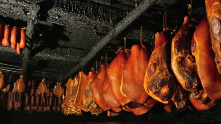 Smoked ham, bacon and sausages hang on hooks in a smoke house in Germany, Schleswig-Holsteinの写真素材