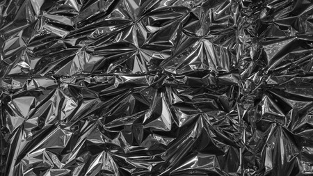 Silver metal foil, wrinkled and shiny.の写真素材