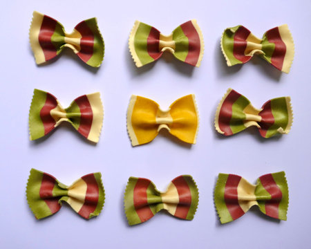 Colorful Pasta, Loop Noodles, Italian Pasta. Nine farfalle in a row, side by side, one below the...