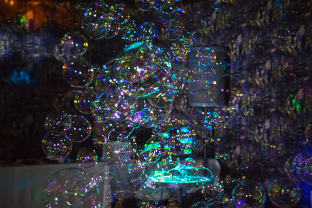 Many beautiful multi-colored bubbles. Festive show. Blurred background. Holiday, anniversary,...