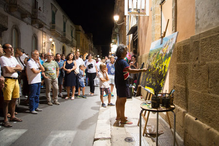White night festival. Street artist paints a picture. People watch his workのeditorial素材