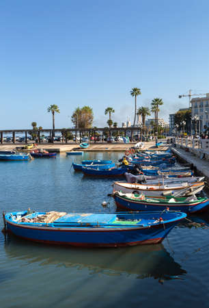 City promenade with sea view and boats. A clear summer day. Blue sky without clouds. Vertical photoの写真素材