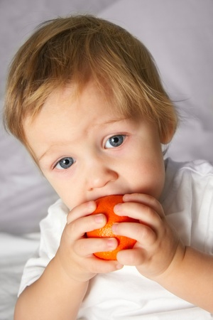 little kid eating an orangeの写真素材