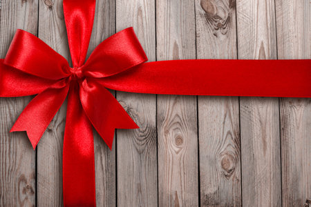 Red ribbon on a wooden backgroundの写真素材