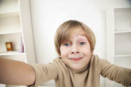 Handsome smiling boy in front of a grey backgroundの写真素材