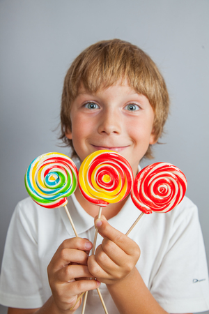 child boy eating lollipop isolatedの写真素材