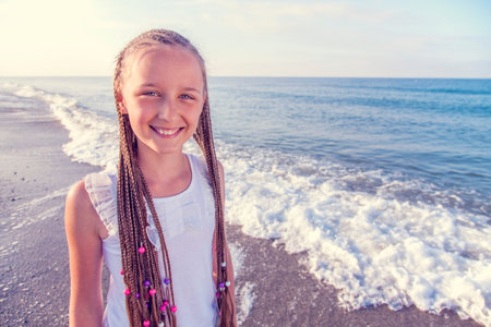 Portrait of a girl with long braids on her head to the sea