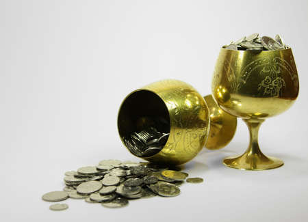 Two golden beakers full of moneyの写真素材