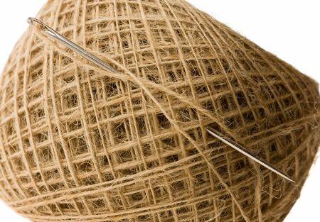 needle in clew with beige thread isolated on whiteの写真素材